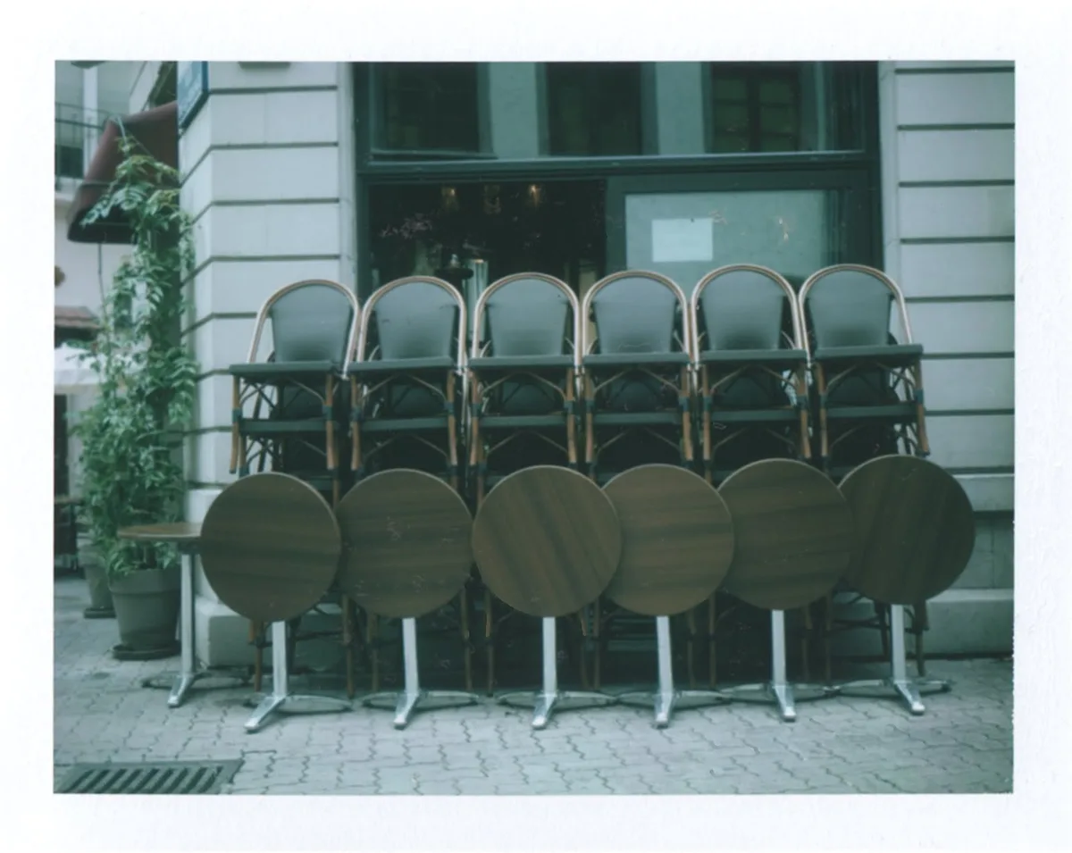 Polaroid de la terrasse, chaises et tables rangées devant la vitrine